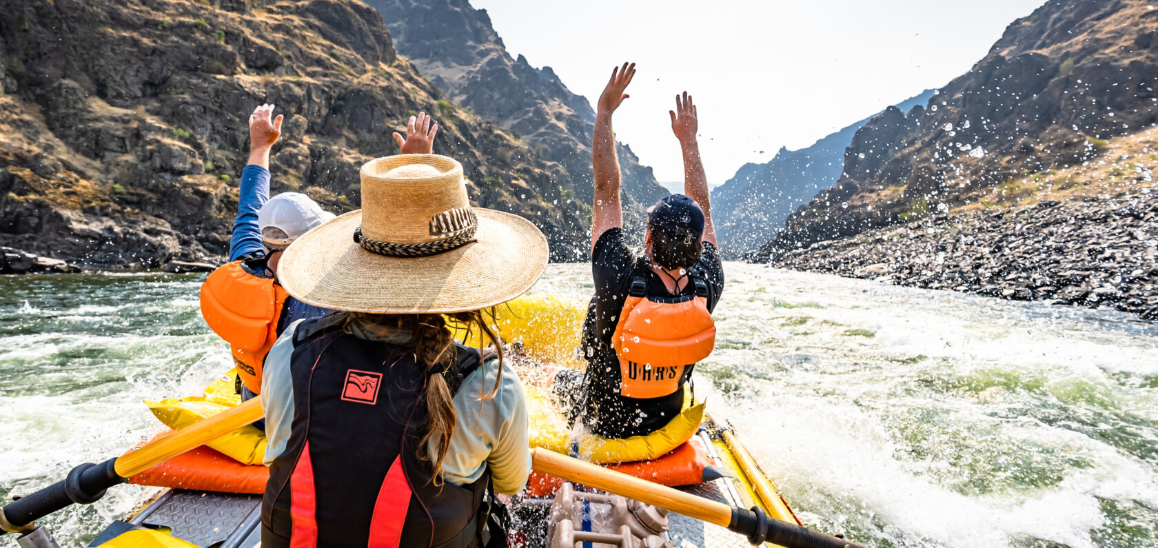 Rafters throwing their hands up while rafting Idaho's Lower Salmon River
