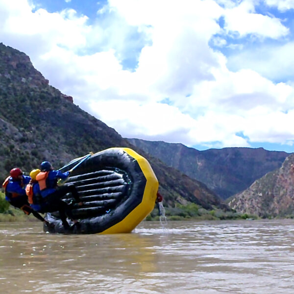 Three guides practice correcting a flipped raft during Dinosaur Whitewater Guide School training