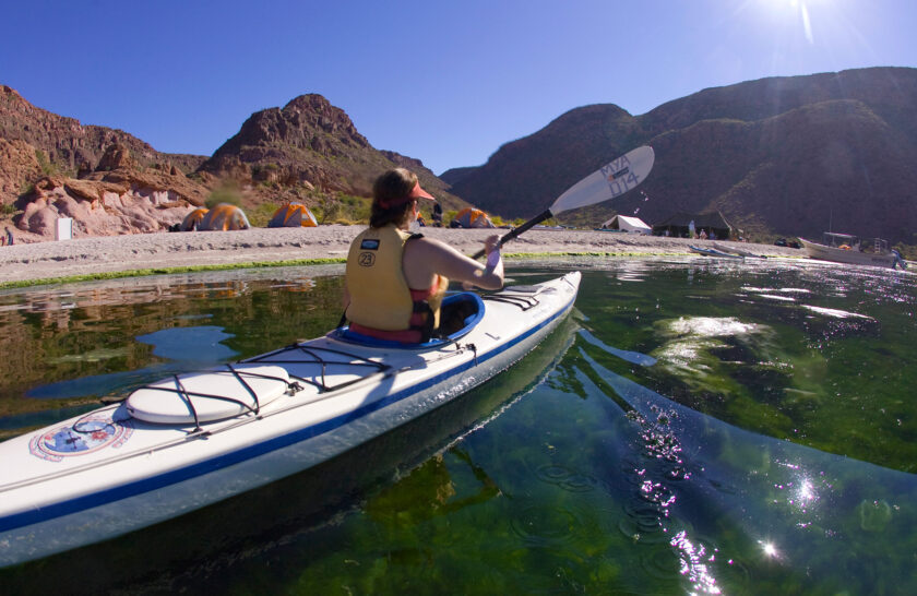 A person paddles a single kayak near the shore of Baja's Espiritu Santo