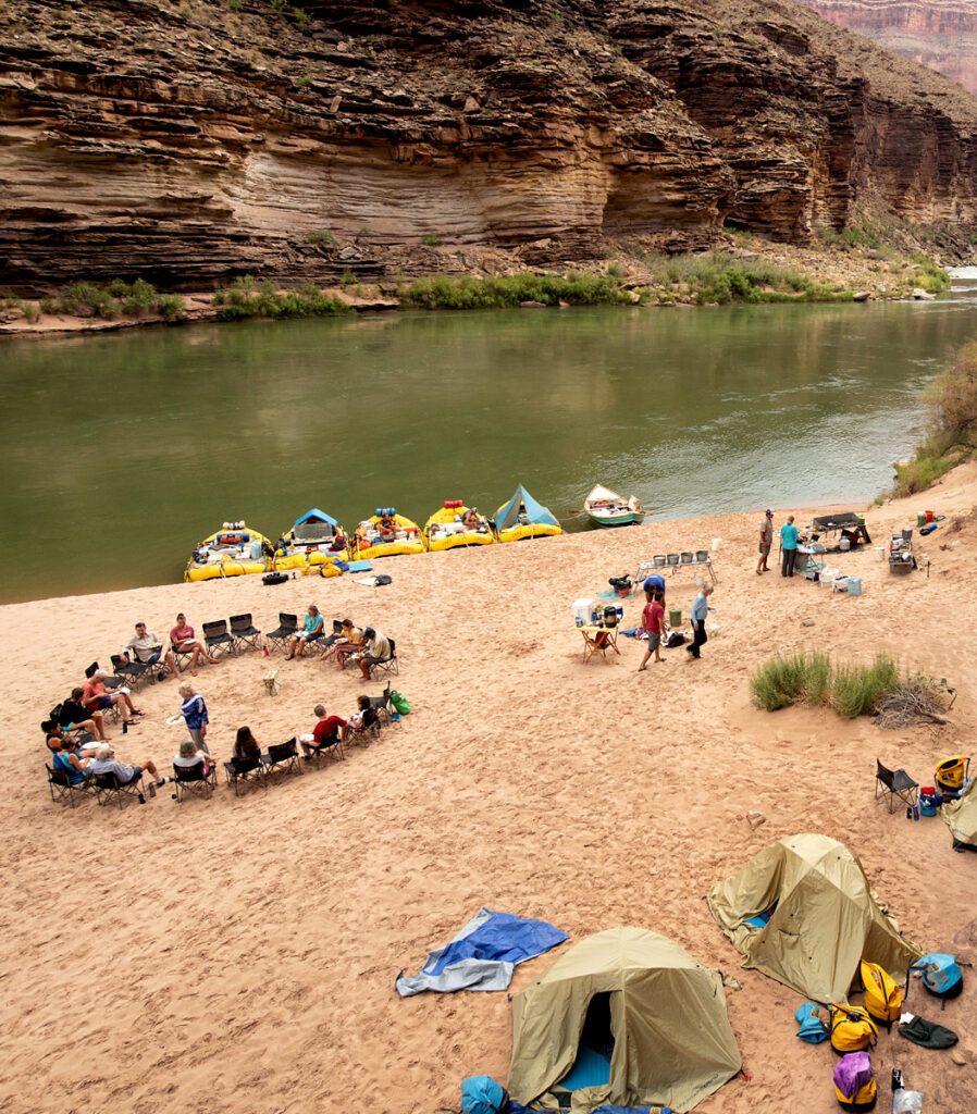 OARS camp from above in Grand Canyon showing moored boats, chair circle, kitchen and tents