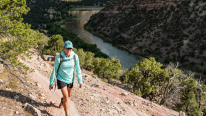 A hiker walks along a trail high above the Green River on a Gates of Lodore trip.
