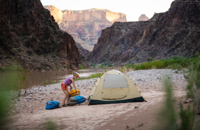A woman sets up her campsite along the Colorado River in Grand Canyon