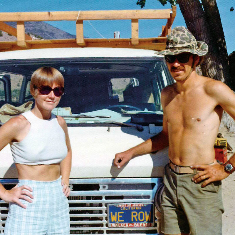Two people standing in front of a car.