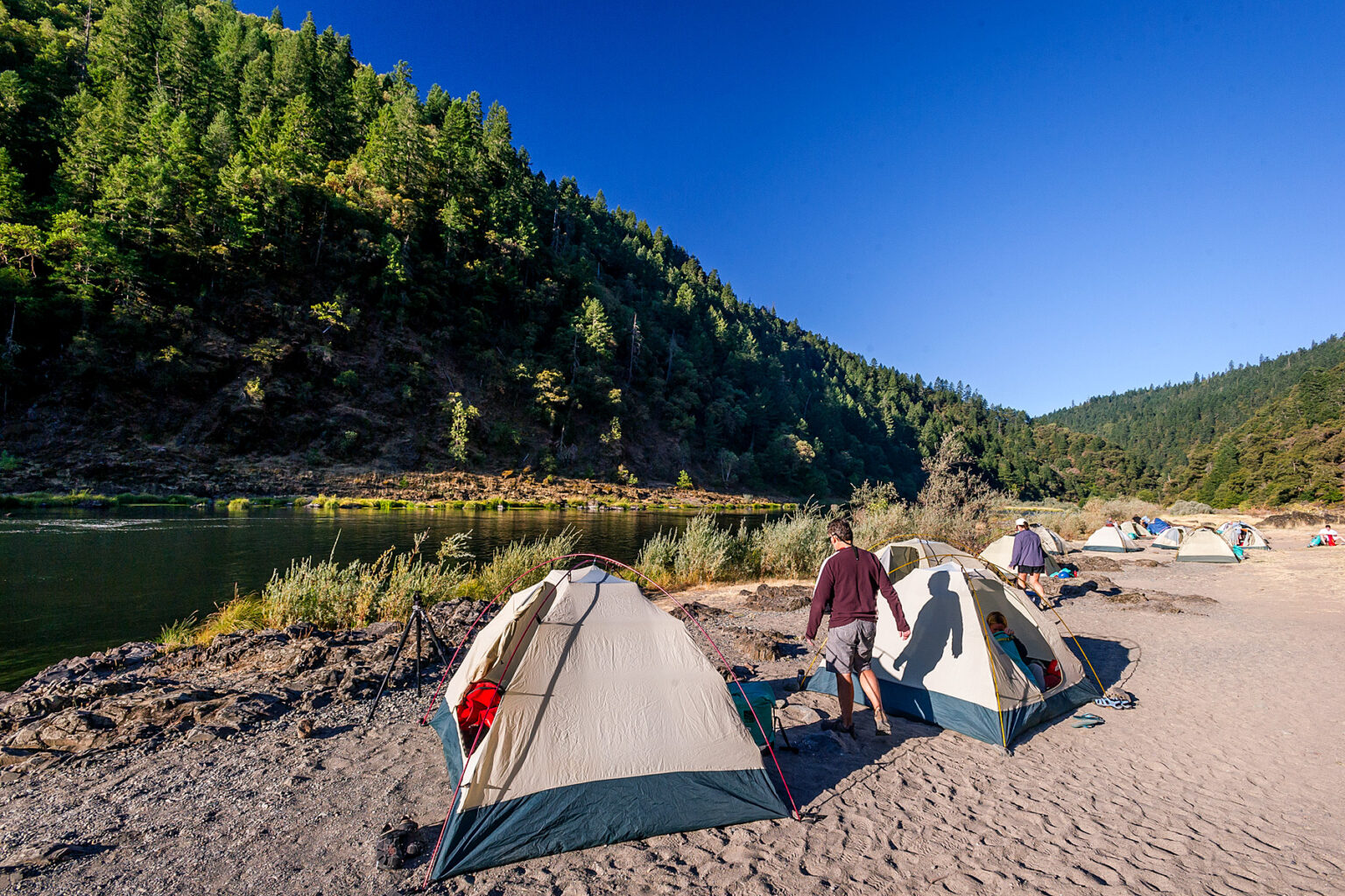 Tents set up along the shore of the Rogue River in Oregon