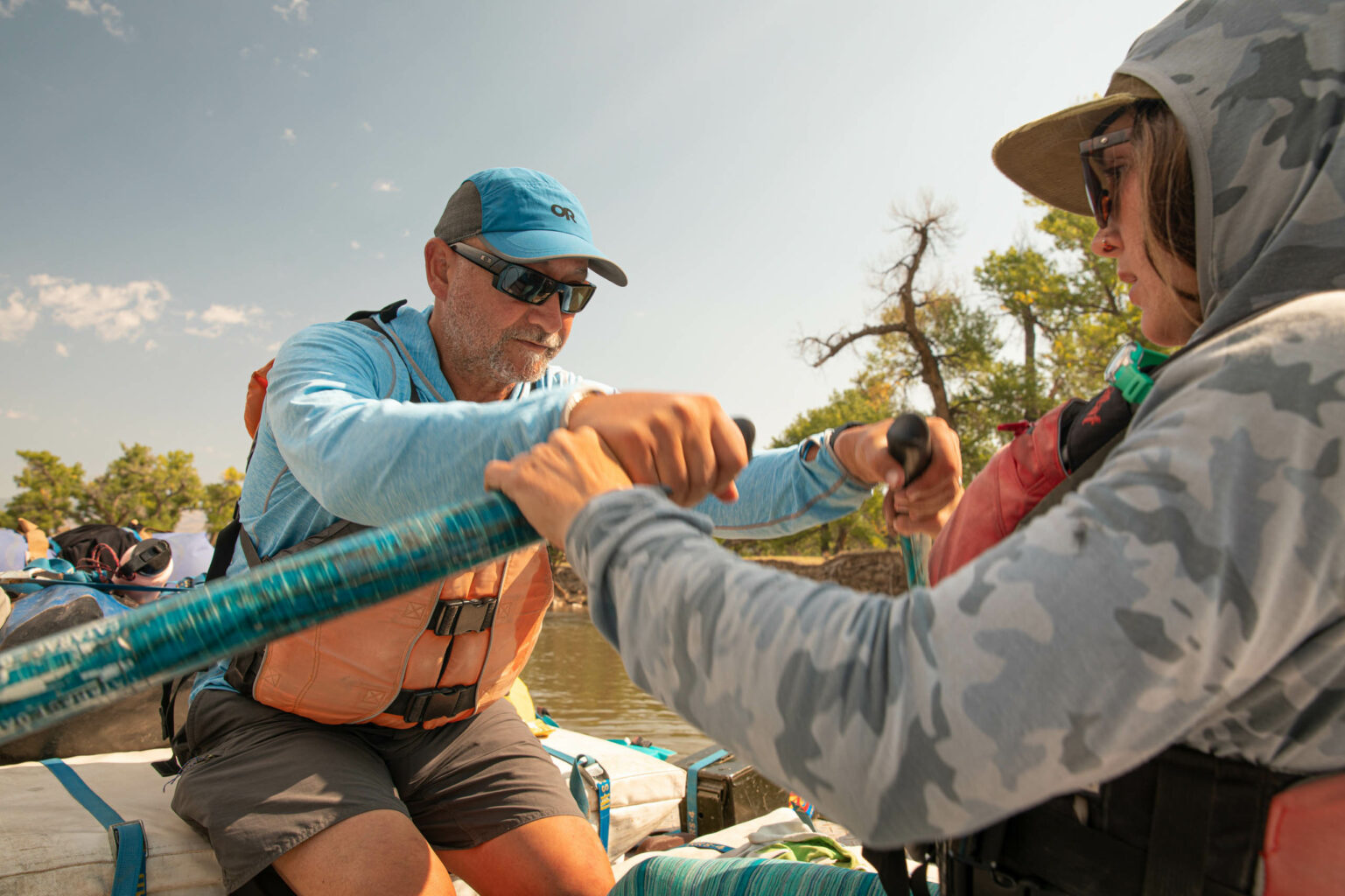 An OARS guide helps a Green River Rowing Clinic guest perfect his oar stroke.