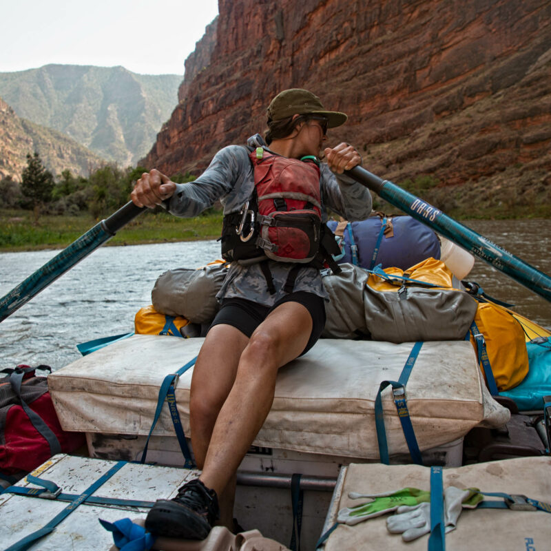 Guest looking over their shoulder as they row in a boat.