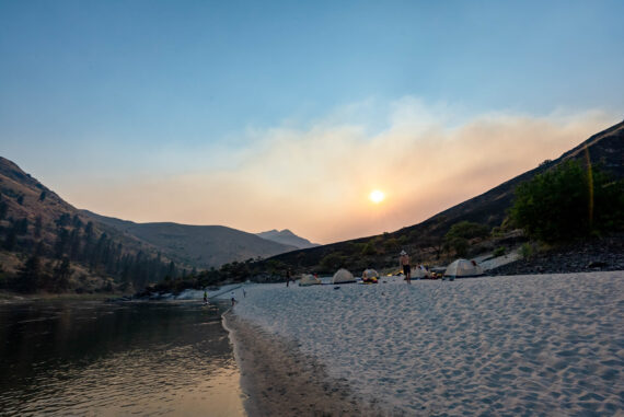 tents pitched on a sandy river bar.