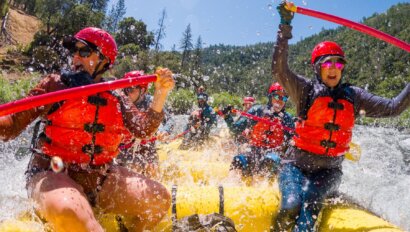 A raft full of people being splashed by whitewater