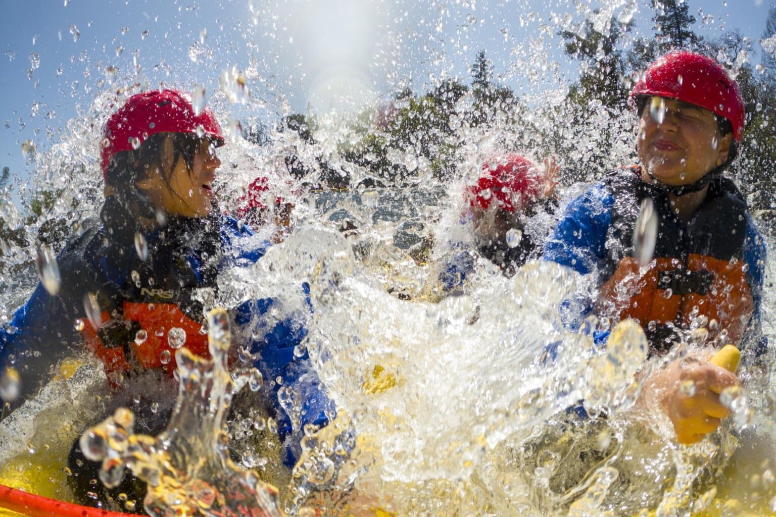 A front view of rafters getting splashed by whitewater on the South Fork of the American River in California