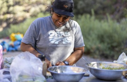 An OARS guide cooks during a Tuolumne River rafting trip