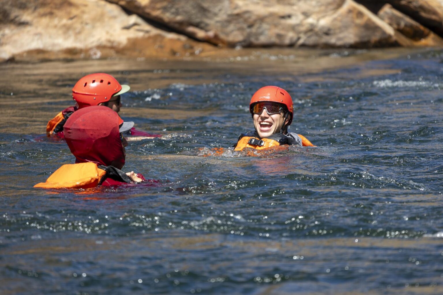 Young men swim in the Tuolumne River during an OARS rafting trip