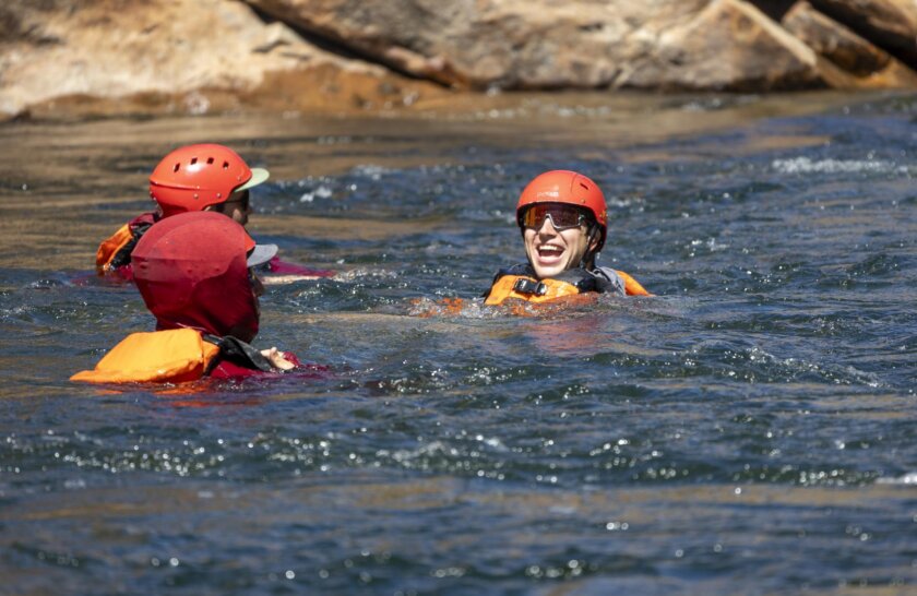 Young men swim in the Tuolumne River during an OARS rafting trip