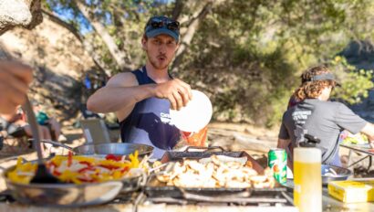 Man making fajitas in a camp kitchen set-up outside